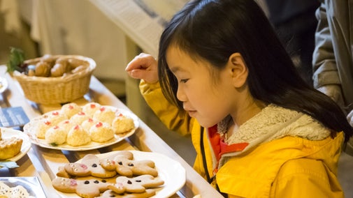 Child choosing a festive biscuit from a display